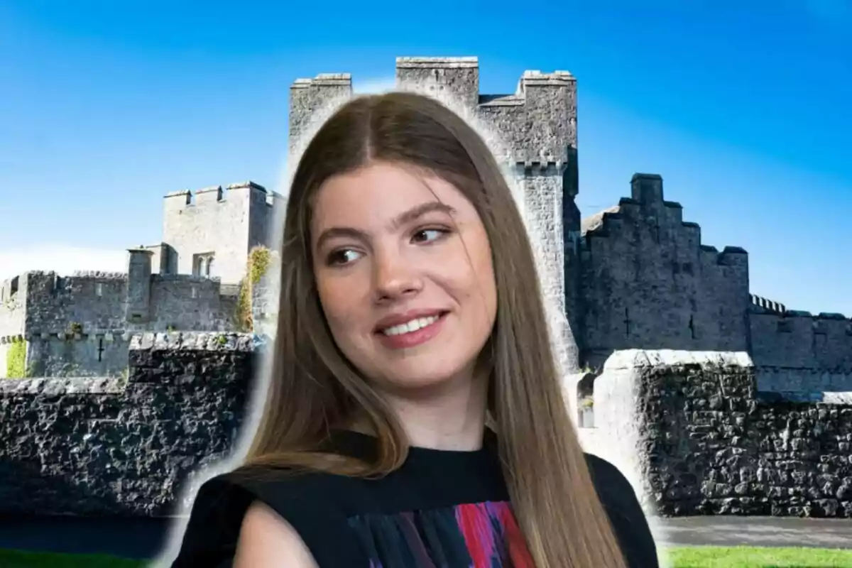 Infanta Sofia smiling with a stone castle in the background under a blue sky.