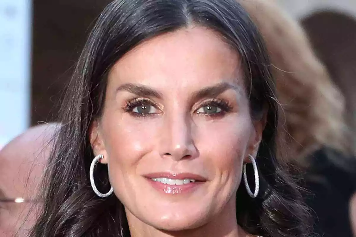 Primer plano de la reina Letizia feliz con unos pendientes de aros plateados